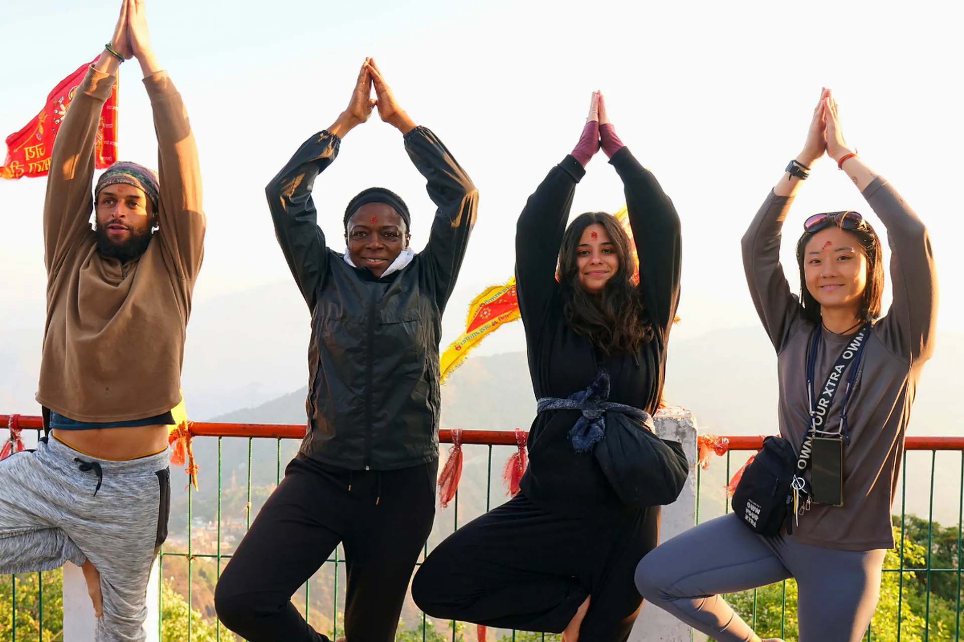 Group tree pose practice at sunrise on Kunjapuri hilltop