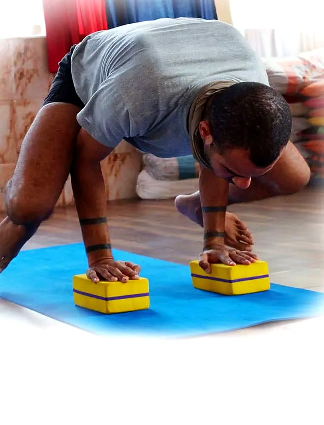 Aspiring yoga teacher practicing plank pose with blocks in Rishikesh