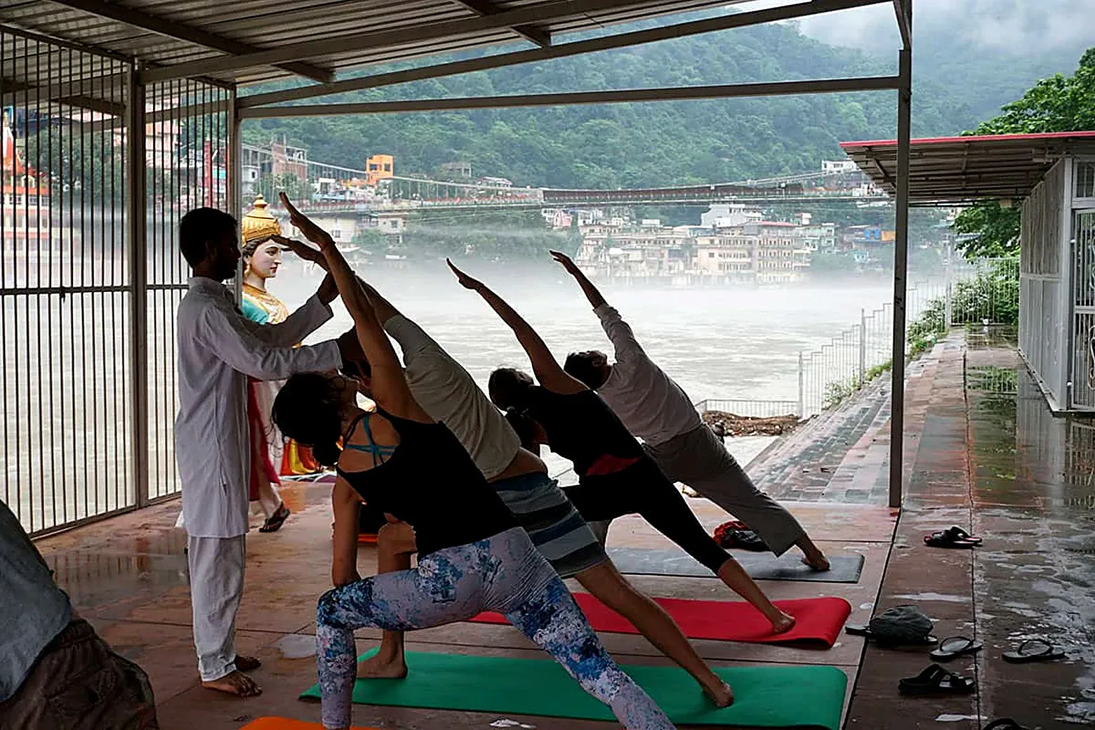 Holistic seeker practicing side angle pose by the riverside in Rishikesh