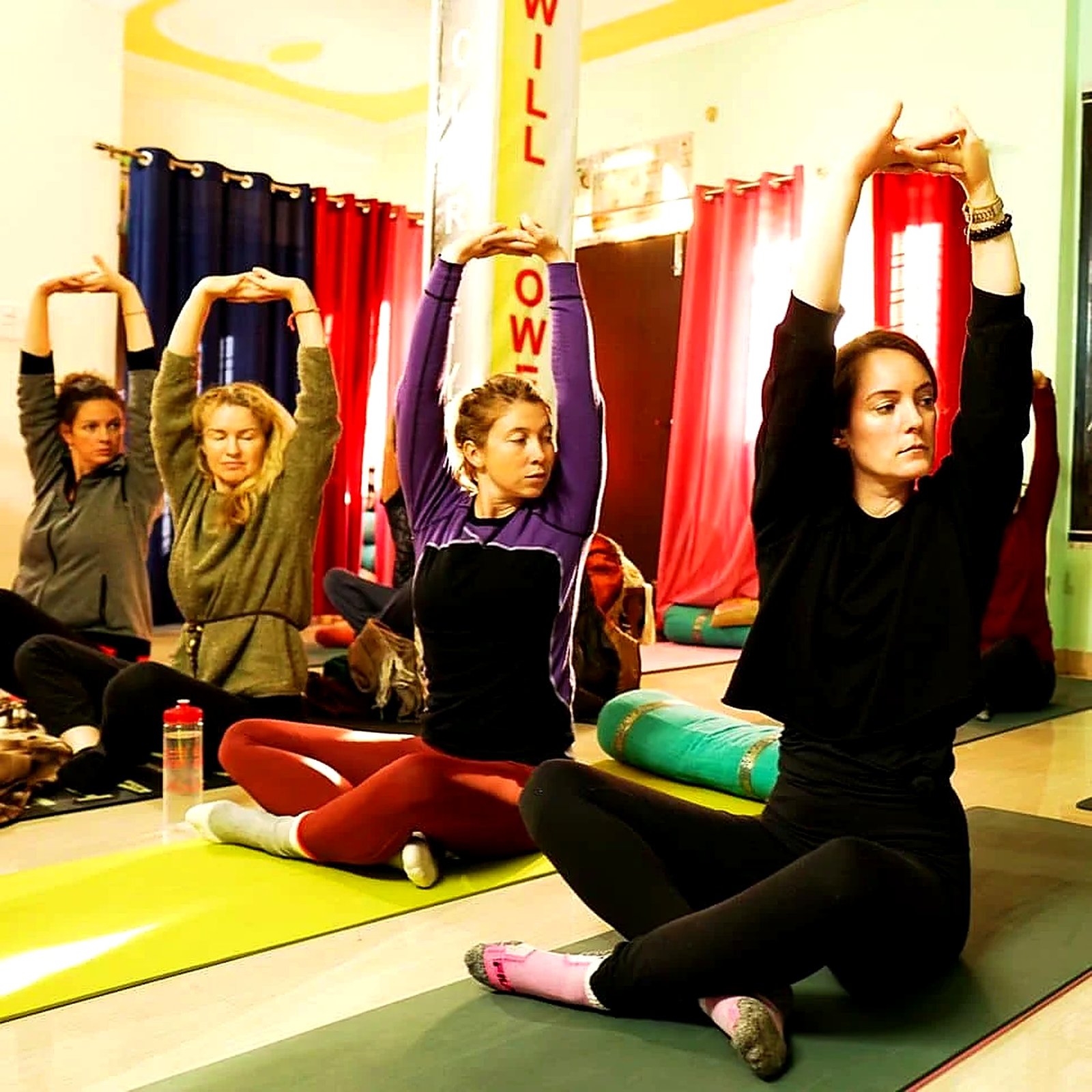 200-hour teacher trainees practicing a seated stretch pose in Rishikesh