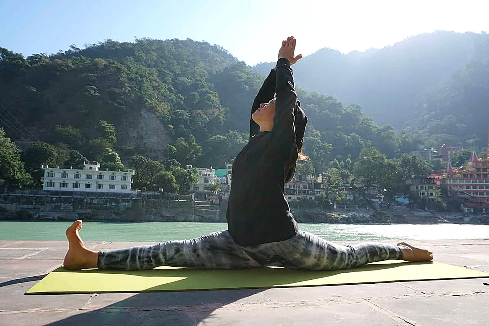 Advanced backbend pose practice on the riverside terrace in Rishikesh