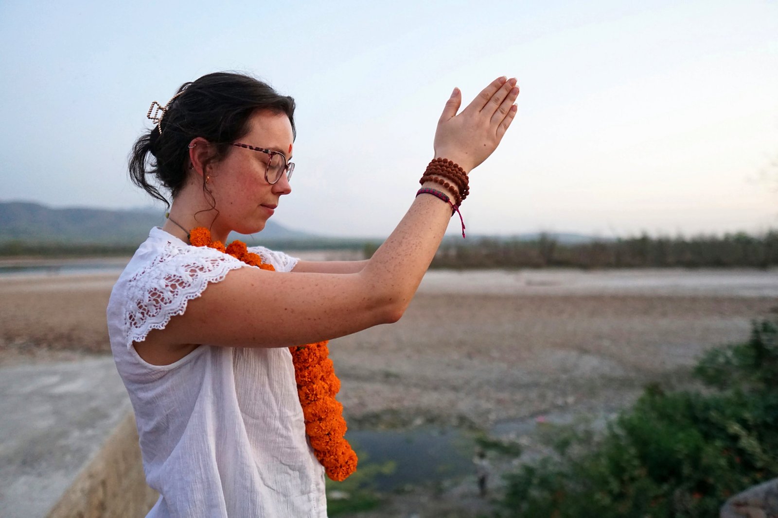 Prayer salutation yoga practice on the Ganges riverbank in Rishikesh