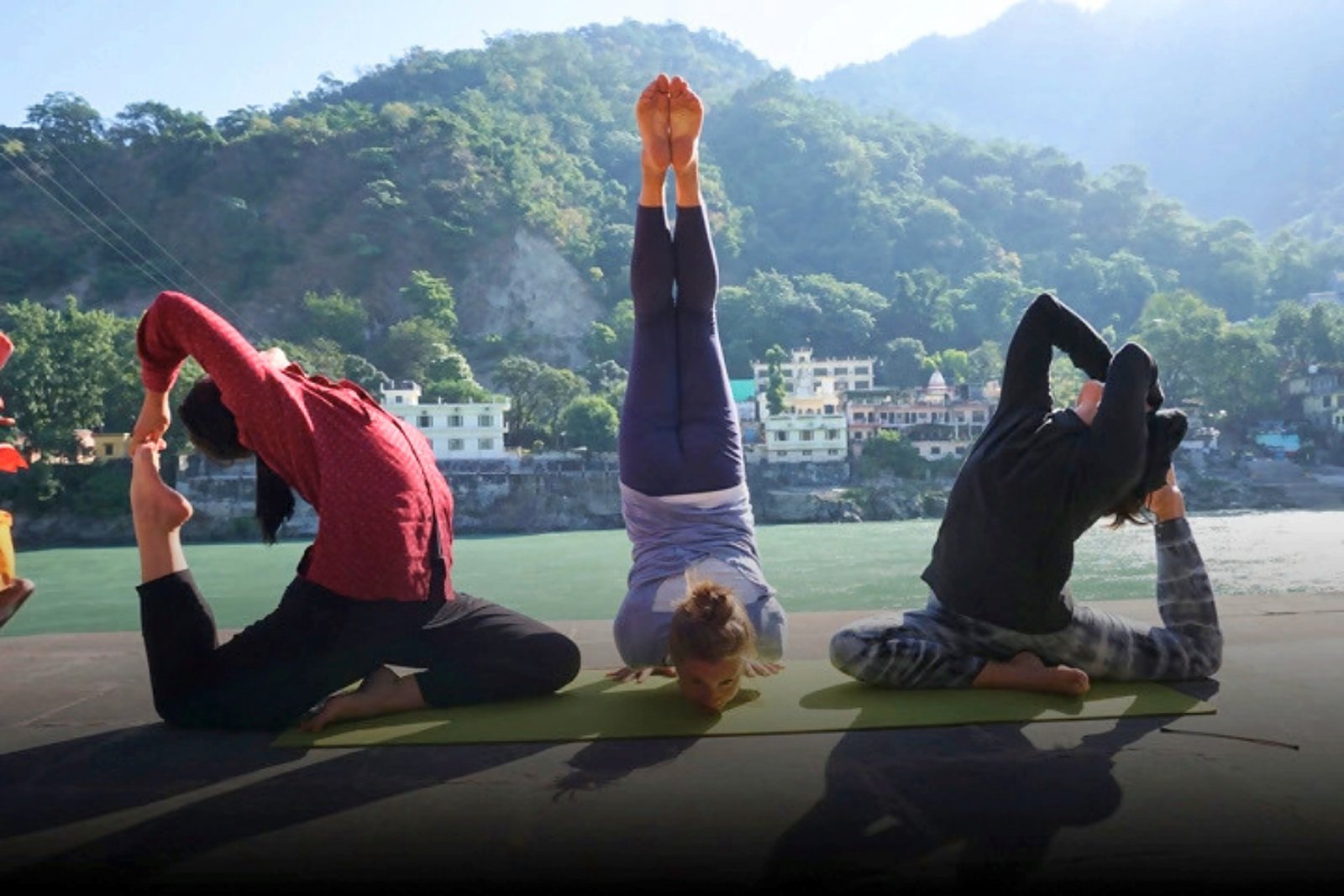 Students practicing on the rooftop shala with a view of the Ganga