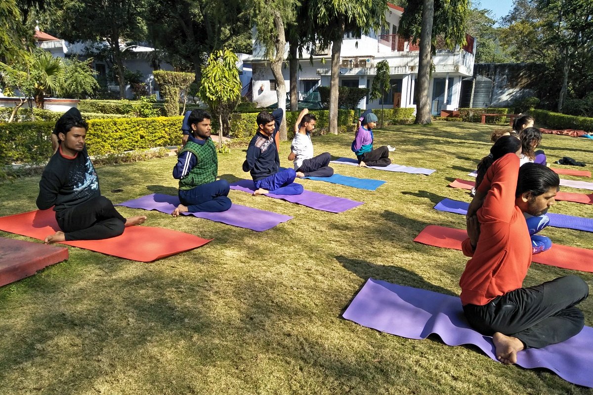 Group practicing seated āsana together in the garden