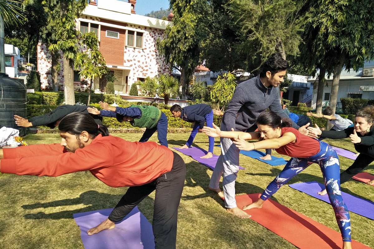 Teacher cueing a student in warrior pose