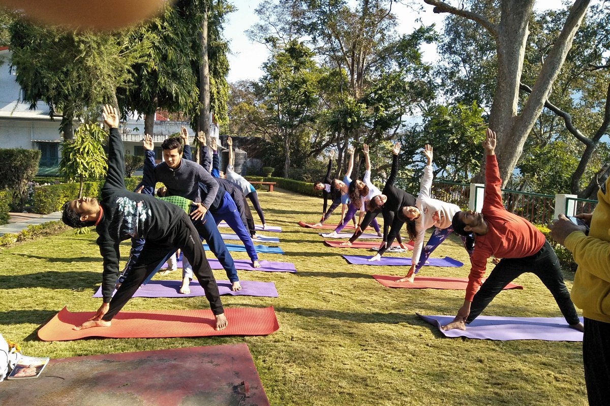 Students in triangle pose during a Haṭha Yoga class in Rishikesh
