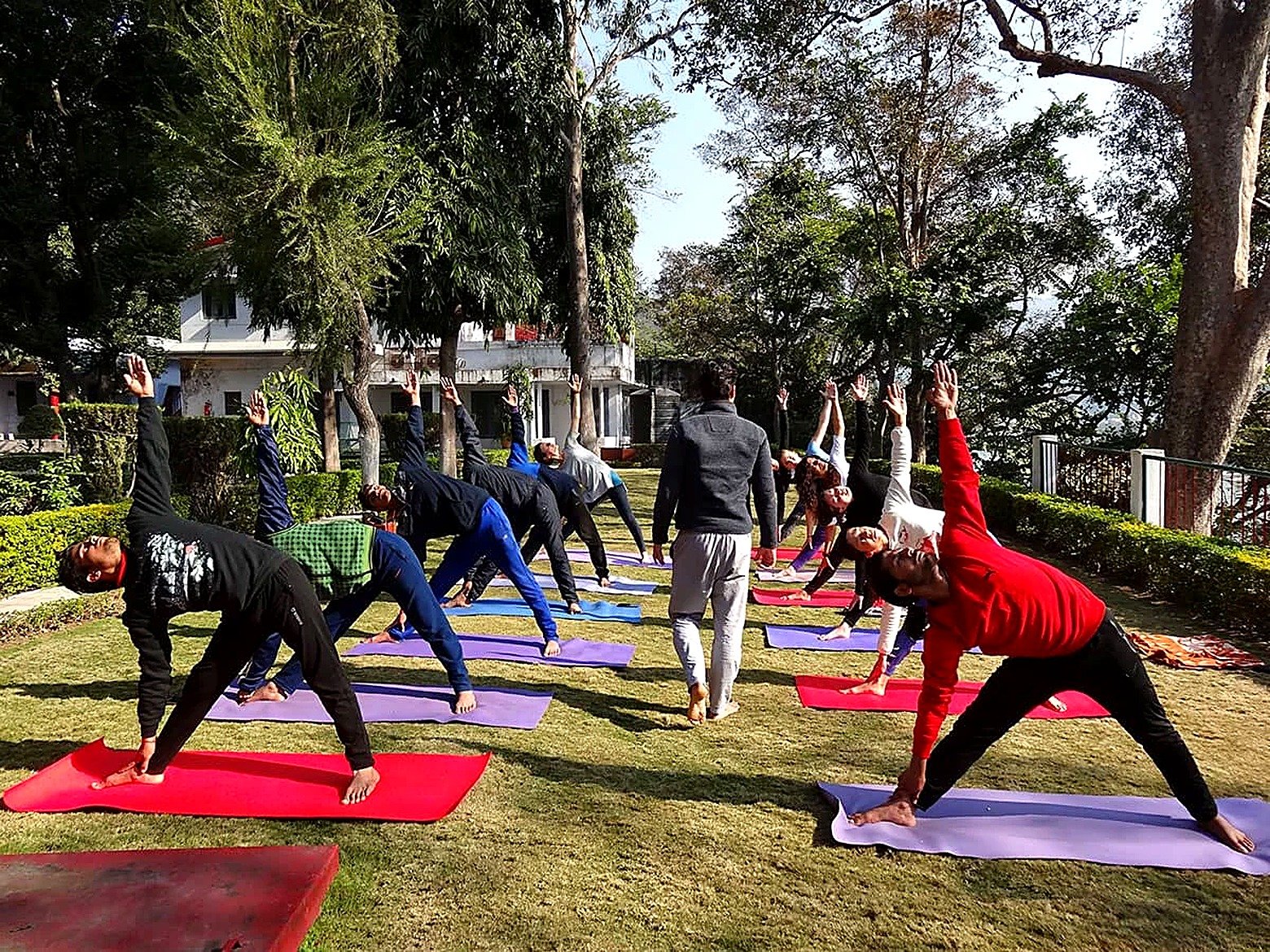 Group practicing triangle pose while studying alignment