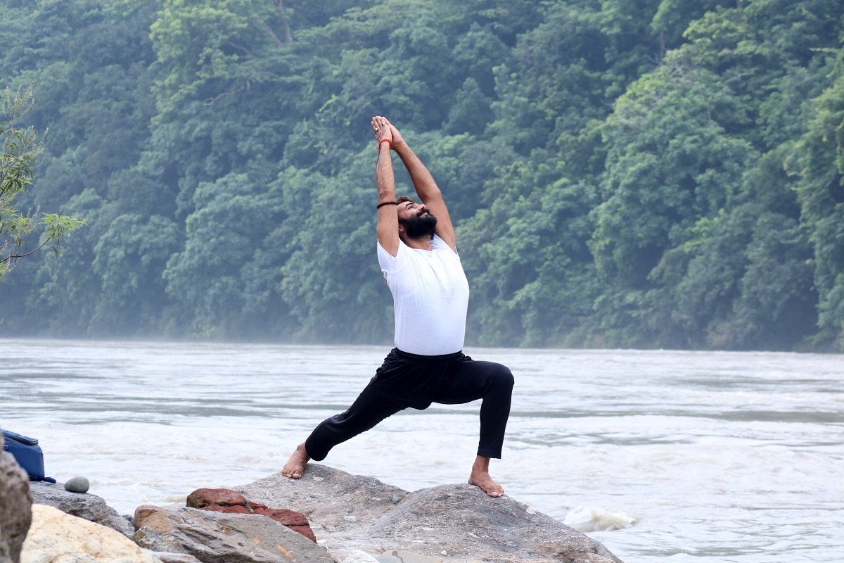 Warrior 1 pose yoga practice by the Ganges river