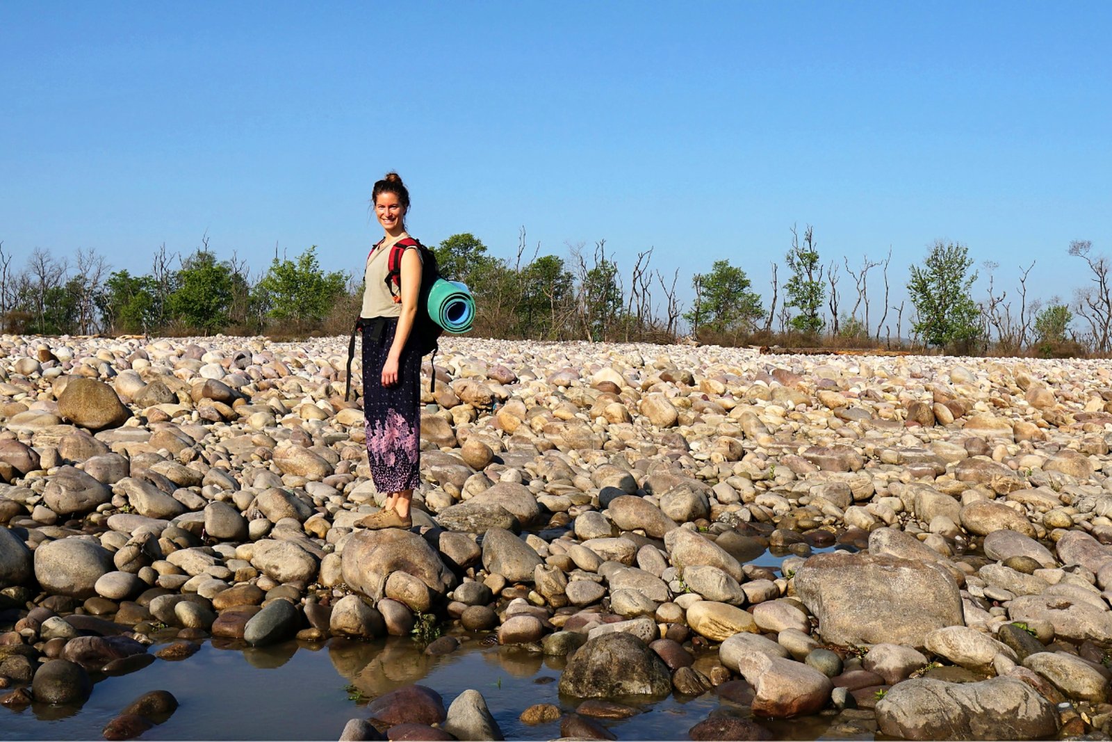 Student walking along a rocky riverbed excursion